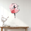 Pink ballerina wall sign displayed on a white paneled wall above a wooden console table