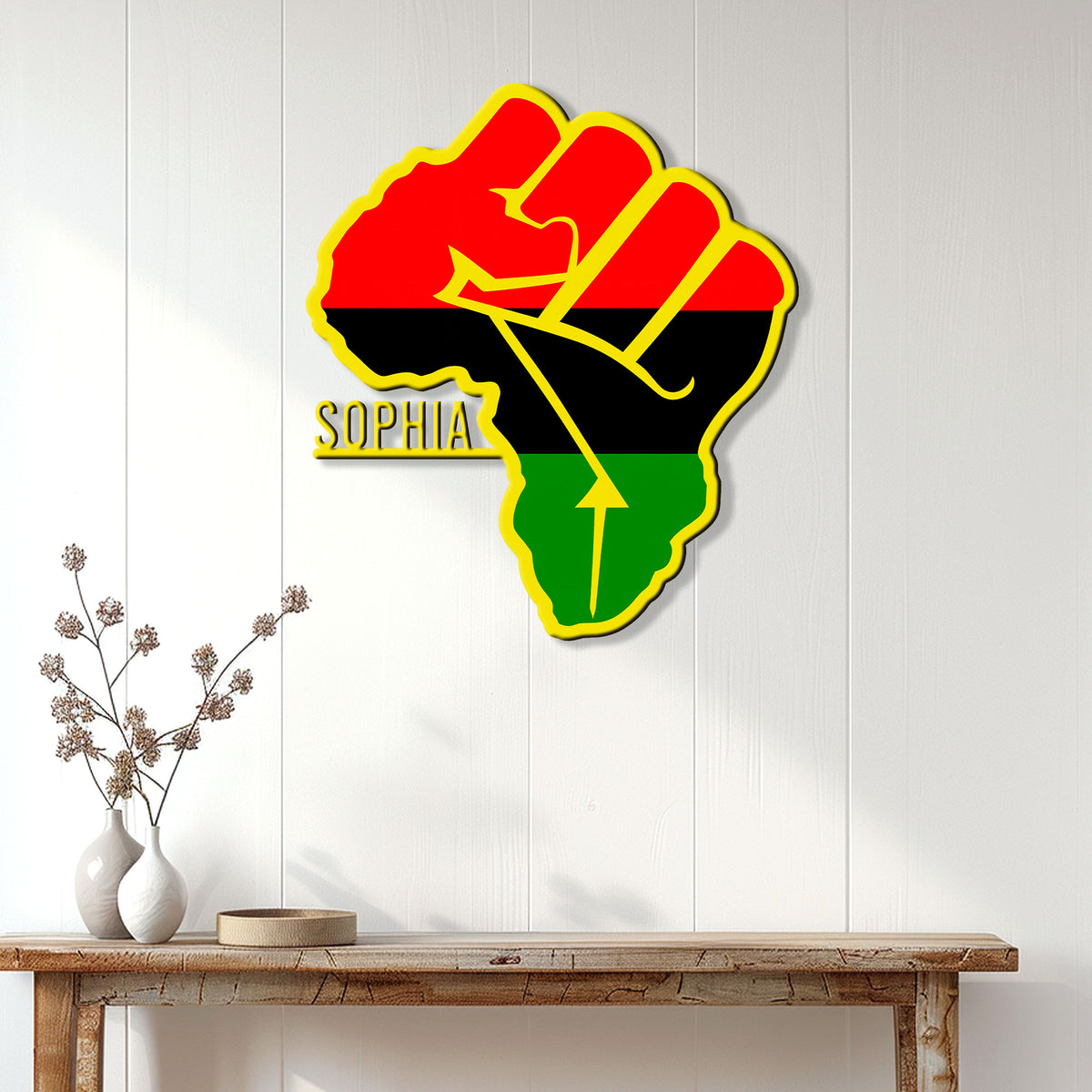 African raised fist wall sign displayed above a console table in a bright modern home