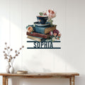 Book lover wall decor displayed above a console table, featuring stacked books, tea, and flowers