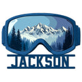 Blue snowmobile goggles metal sign featuring a snowy mountain range and evergreen forest scene