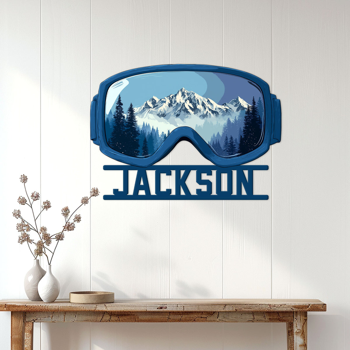 Snowmobile goggles wall sign displayed on a white paneled wall above a rustic console table