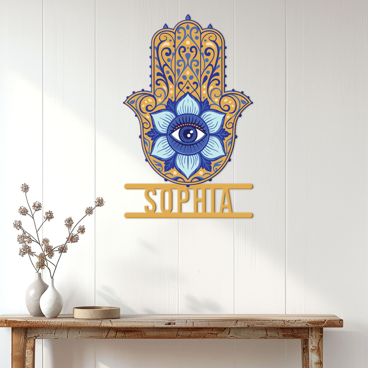 Blue and gold Hamsa evil eye wall sign displayed above a console table in a bright home