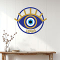 Blue and gold evil eye wall sign displayed above a console table in a bright home interior