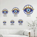 Evil eye metal wall sign shown in multiple size options above a living room sofa