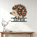Hedgehog metal wall sign displayed on a white paneled wall above a wood console table