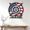 Patriotic archery metal sign displayed on a light wood wall above a console table