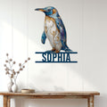 Ornate blue penguin metal wall sign displayed above a console table in a bright home entryway