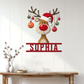 Festive reindeer metal wall sign displayed on a white paneled wall above a rustic console table