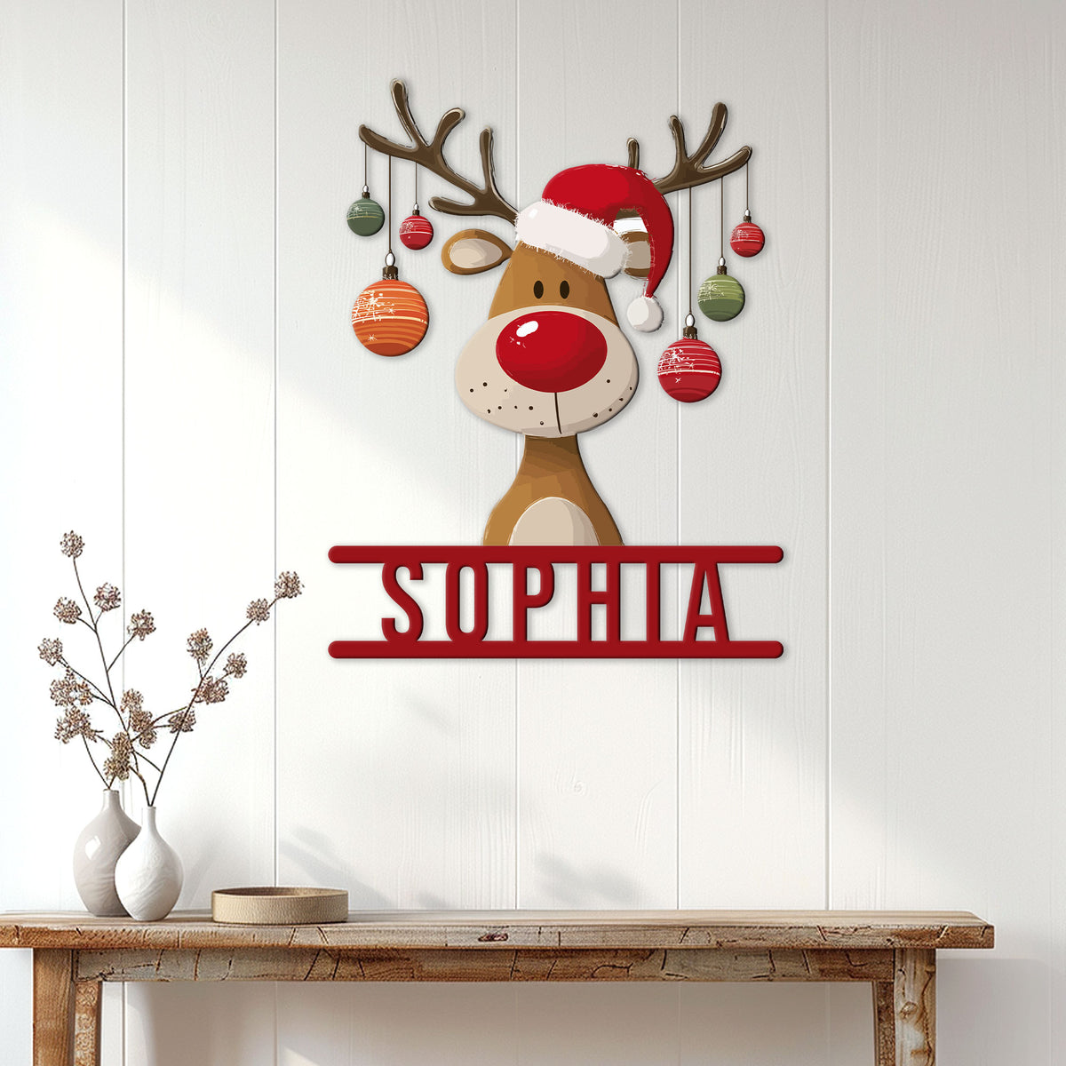 Festive reindeer metal wall sign displayed on a white paneled wall above a rustic console table