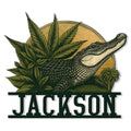 Custom alligator metal sign featuring a detailed reptile portrait surrounded by tropical foliage and a sunset