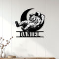 Astronaut wall sign displayed on a light wood-paneled wall above a console table
