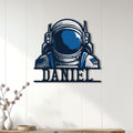 Astronaut wall decor displayed on a light wood-paneled wall in a modern living space