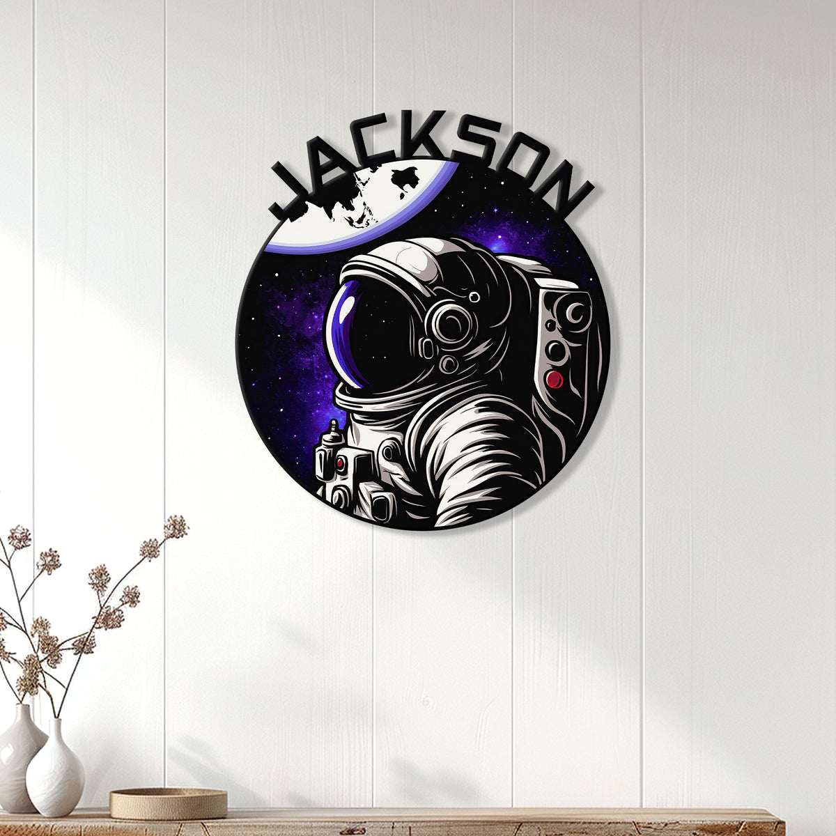 Astronaut metal wall decor displayed on a white paneled wall above a console table