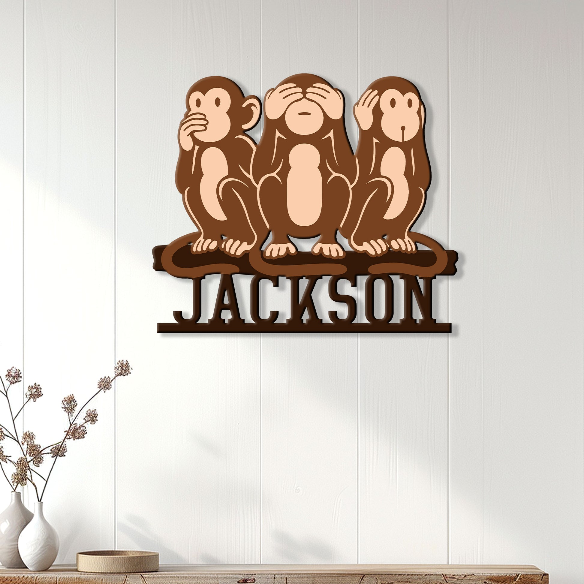 Three wise monkeys wall sign displayed on a light paneled wall in a modern living room
