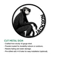 Seated monkey cut metal sign shown in a product feature graphic with a bold circular border