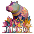 Colorful hippo metal sign surrounded by vibrant tropical flowers and patterned leaves