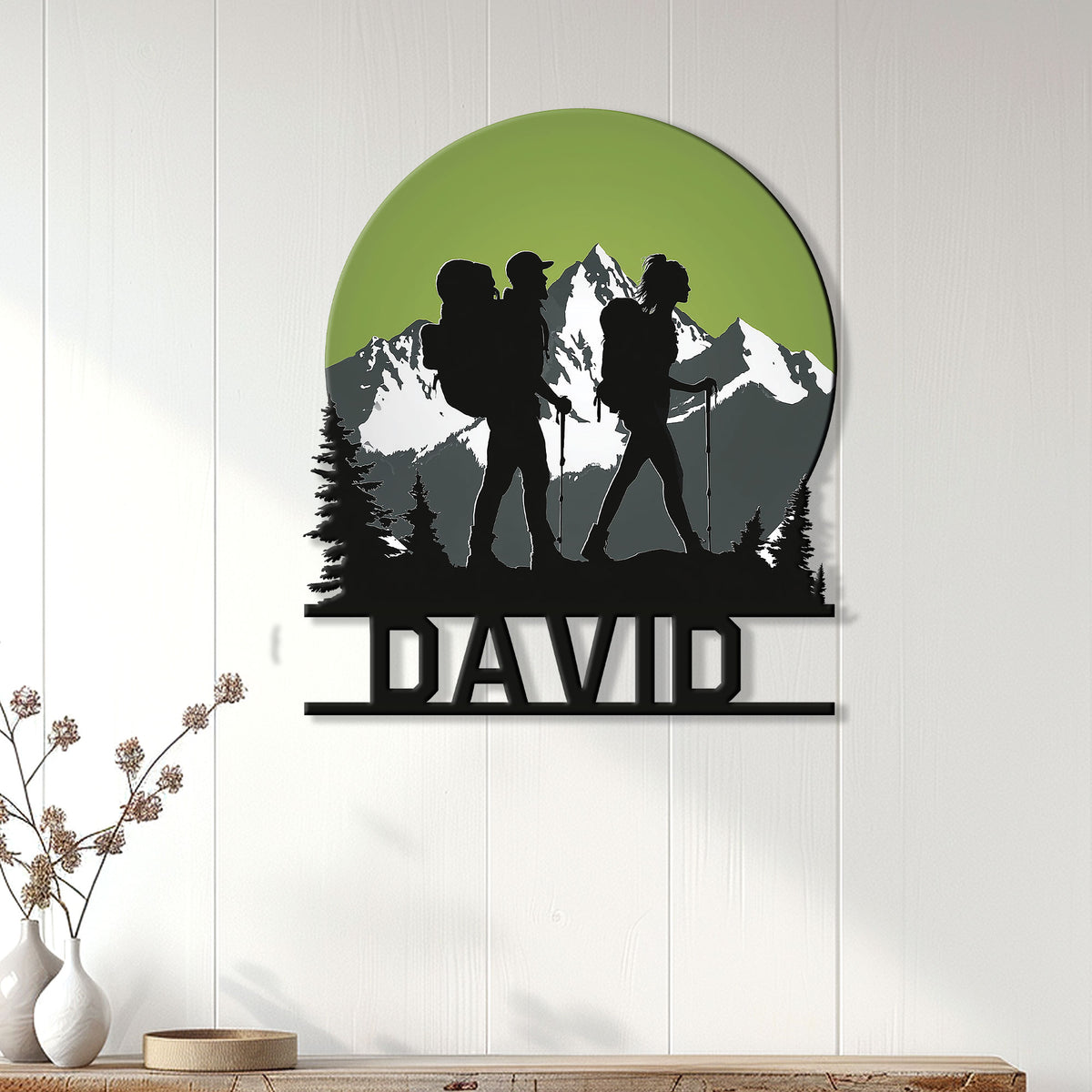 Hiking wall decor displayed on a light paneled wall, featuring family hikers and a mountain landscape