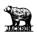 Bear metal sign featuring a mountain landscape, pine forest, river, and moon in a bold silhouette design