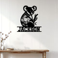 Koala metal wall sign displayed on a bright paneled wall above a rustic console table