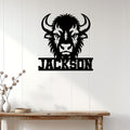 Black bison head metal sign displayed on a light wood-paneled wall in a rustic interior