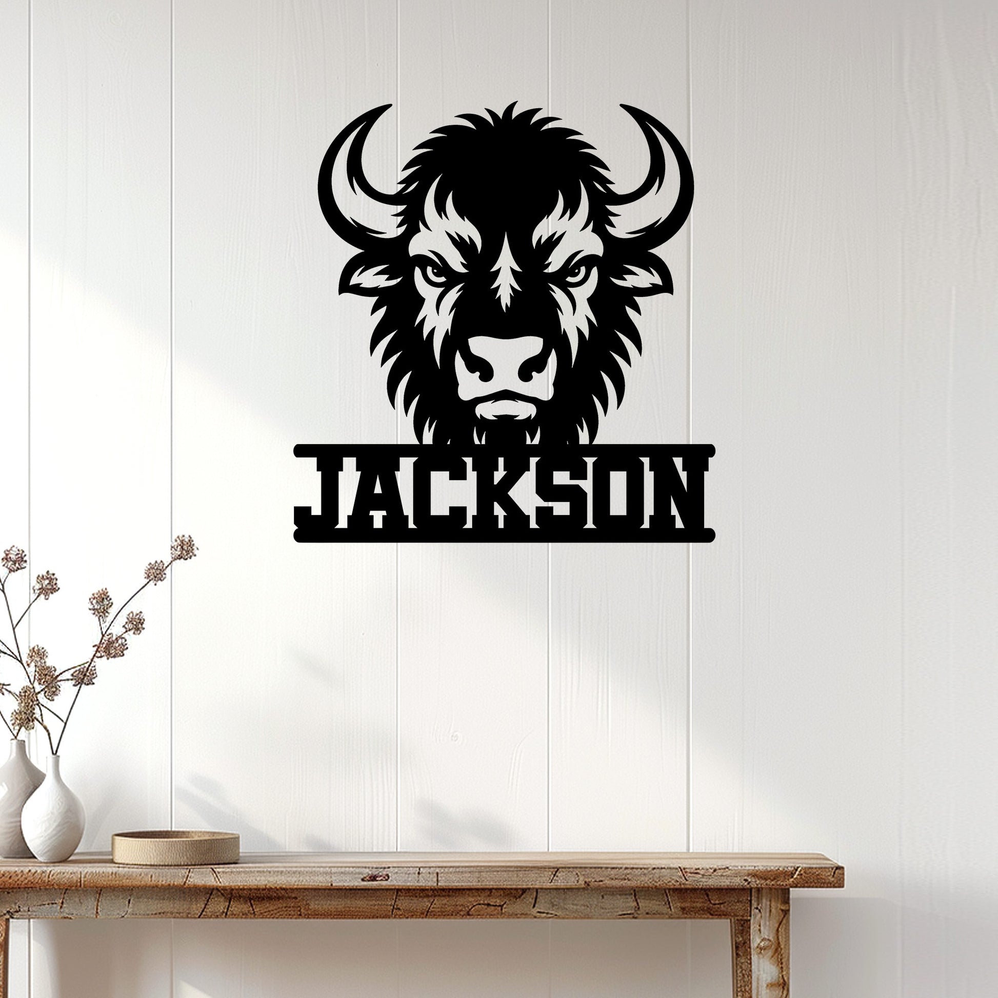 Black bison head metal sign displayed on a light wood-paneled wall in a rustic interior