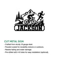 Cut metal triathlon sign with swim, bike, and run silhouettes in a mountain landscape design