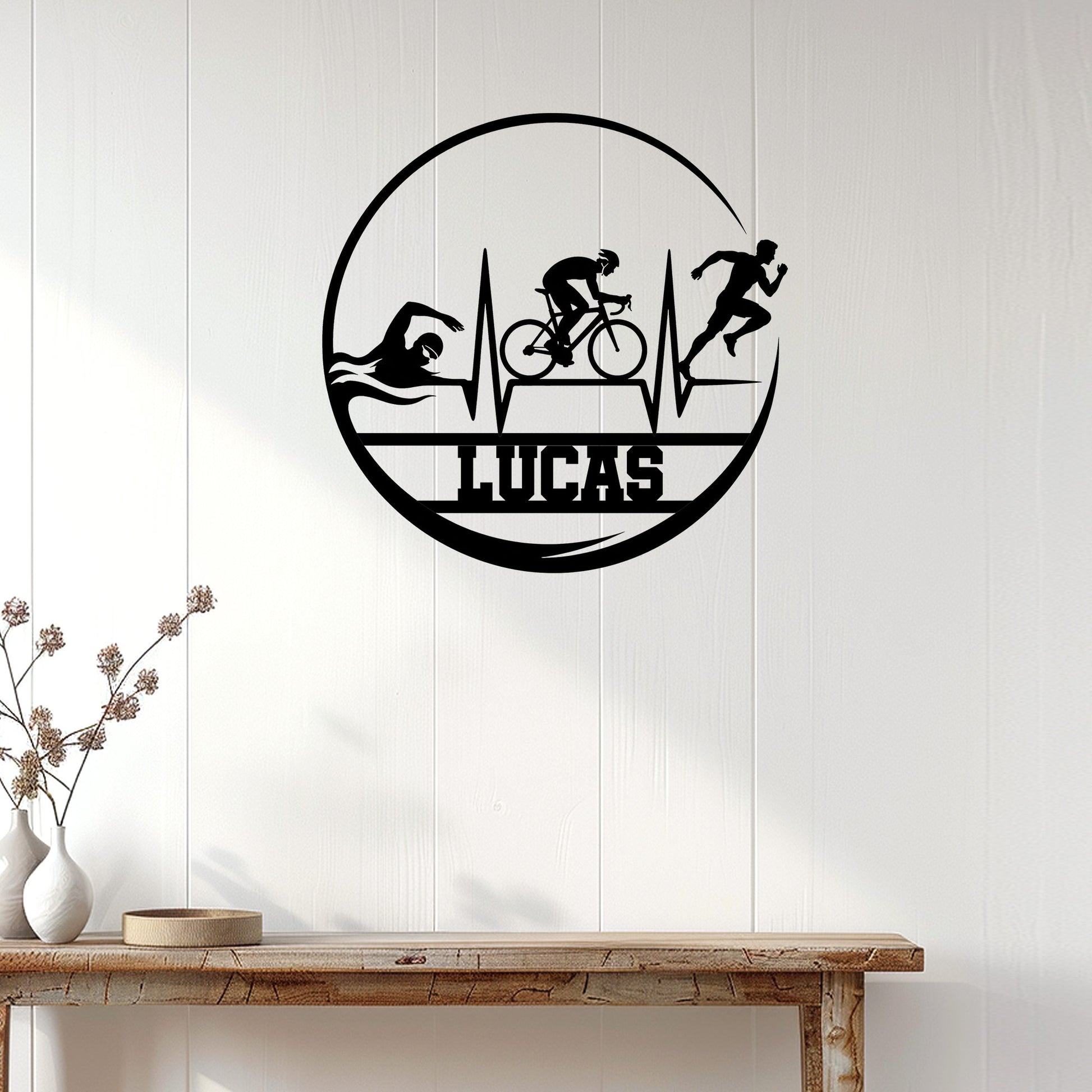 Triathlon wall sign displayed on white wood paneling, featuring swimmer, cyclist, and runner silhouettes