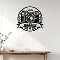 Photographer metal sign displayed on a white paneled wall above a rustic console table