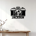Custom photographer metal sign displayed on a light wood wall above a rustic console table