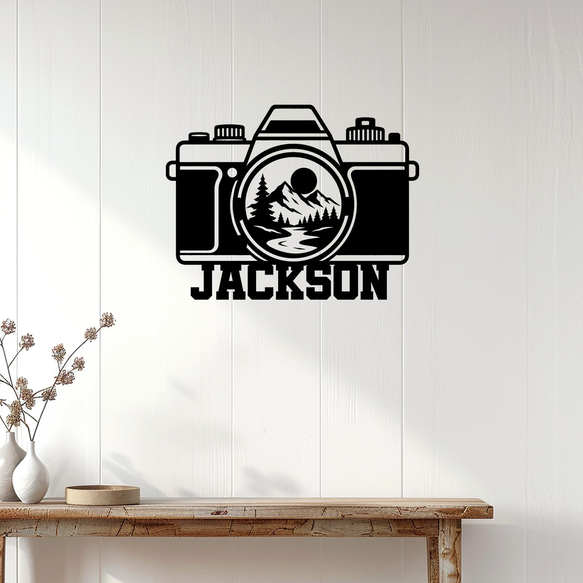 Custom photographer metal sign displayed on a light wood wall above a rustic console table