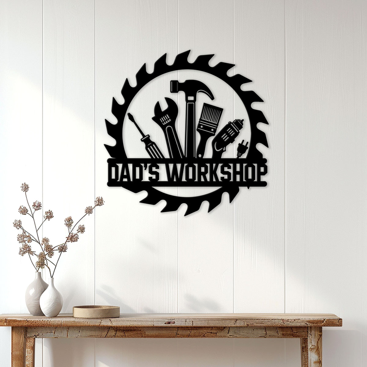 Black Dad's Workshop metal sign displayed on a white paneled wall above a rustic wood console