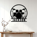 Black drum set metal wall sign displayed above a console table in a bright home interior