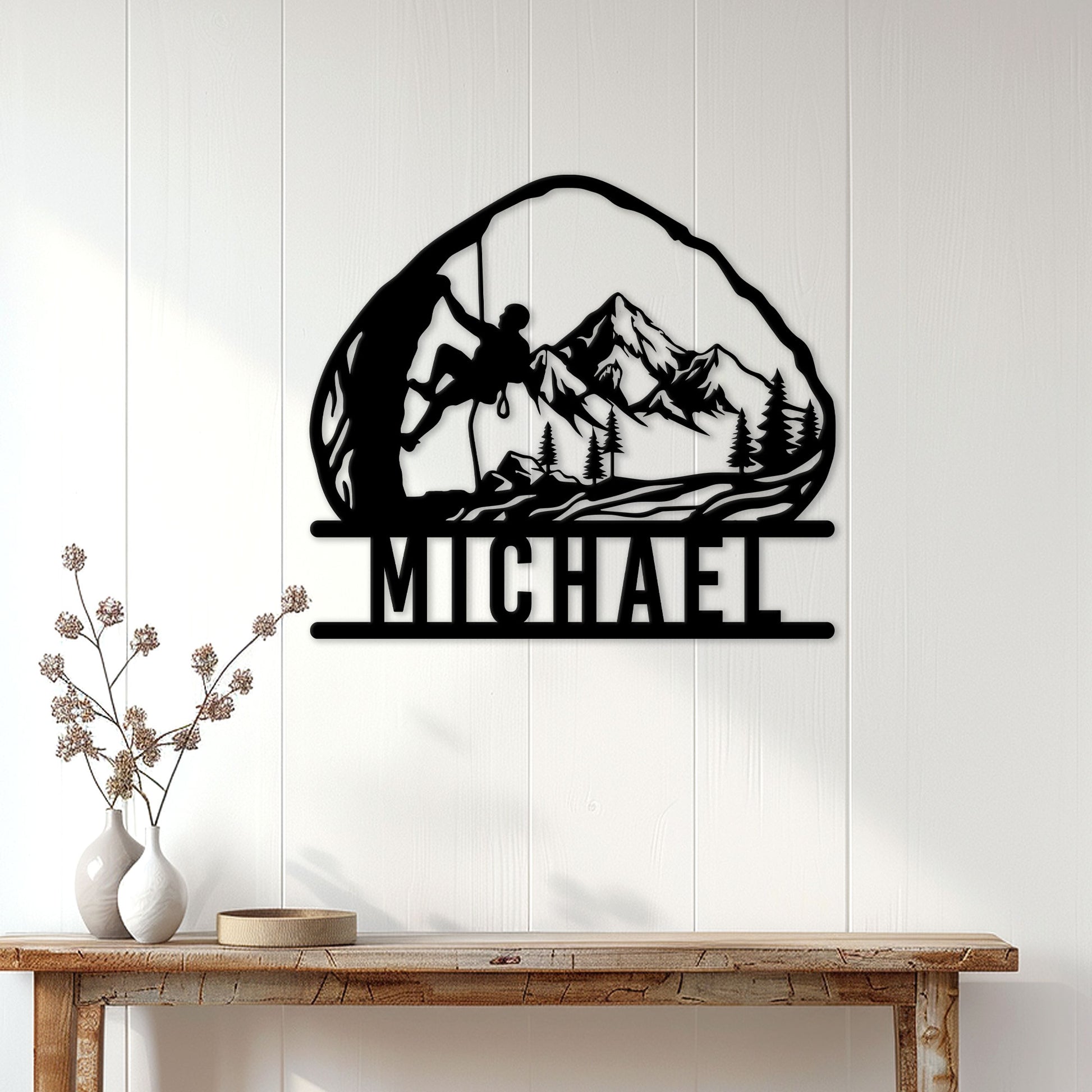 Rock climbing wall sign displayed on a light wood-paneled wall above a console table