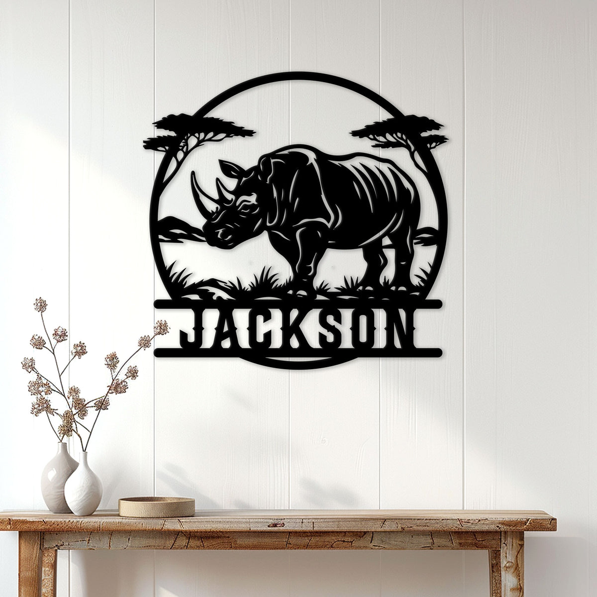 Black rhino metal wall sign displayed above a console table in a bright home interior