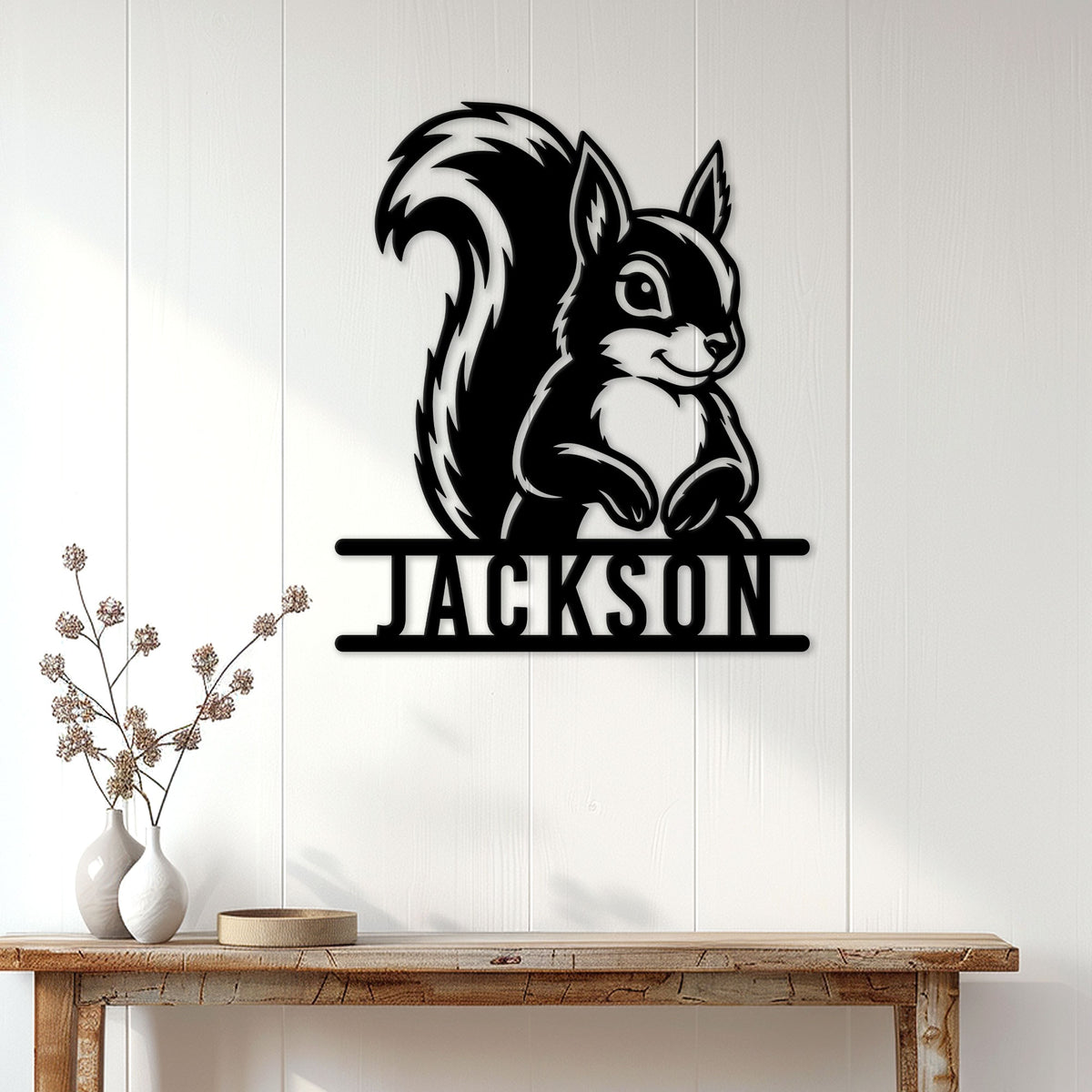 Black squirrel wall sign displayed on a white paneled wall above a rustic console table