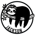 Black metal sign featuring a relaxed sloth hanging from a leafy branch inside a circular frame