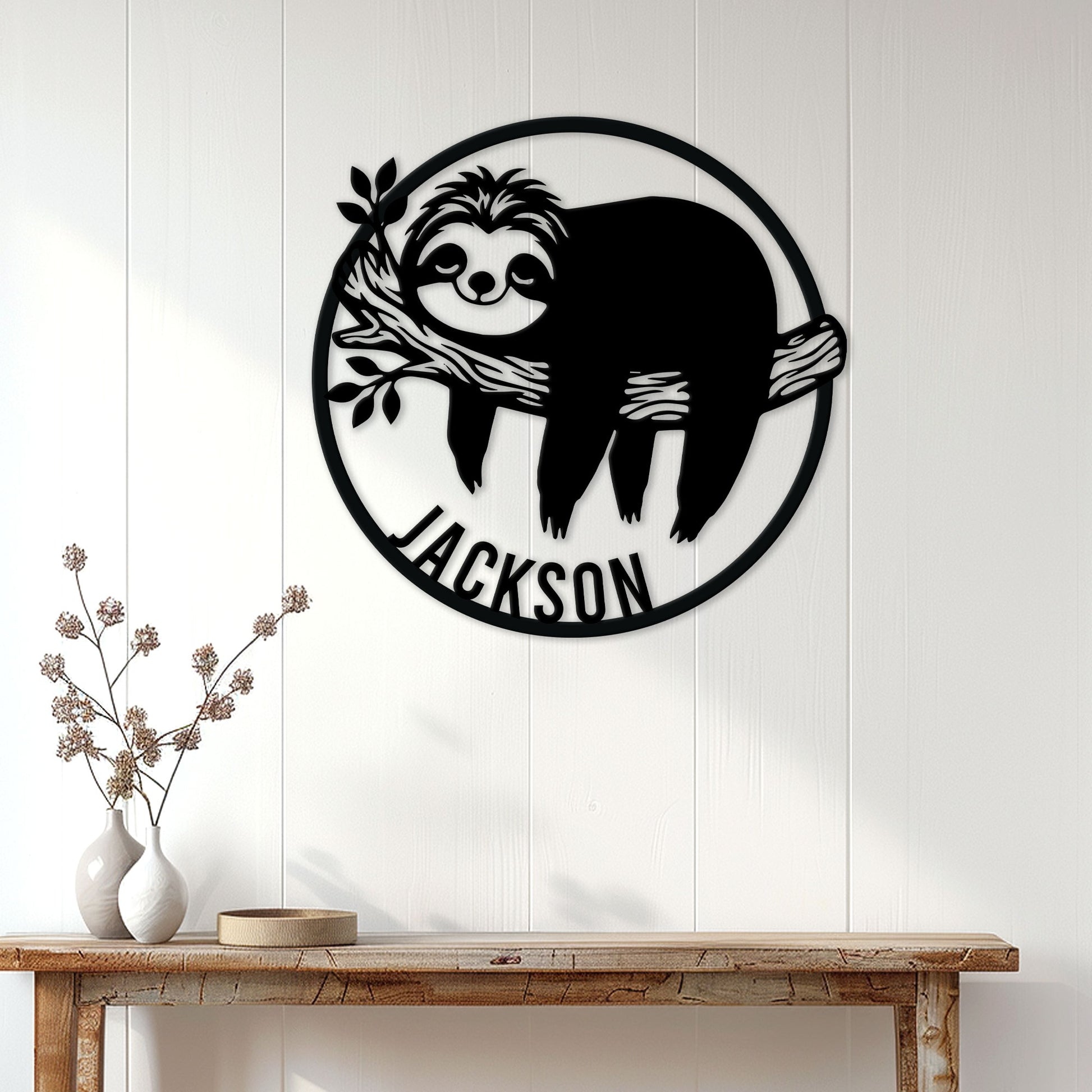 Sloth metal wall sign displayed on a white paneled wall above a rustic console table