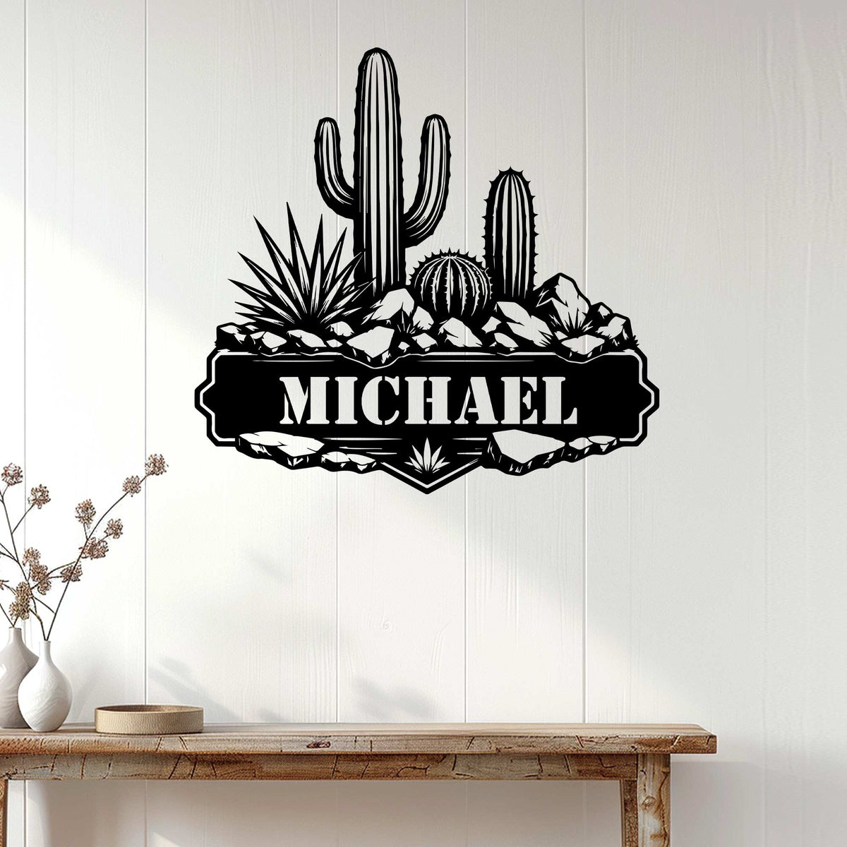 Cactus metal wall sign displayed on a light wood-paneled wall above a console table