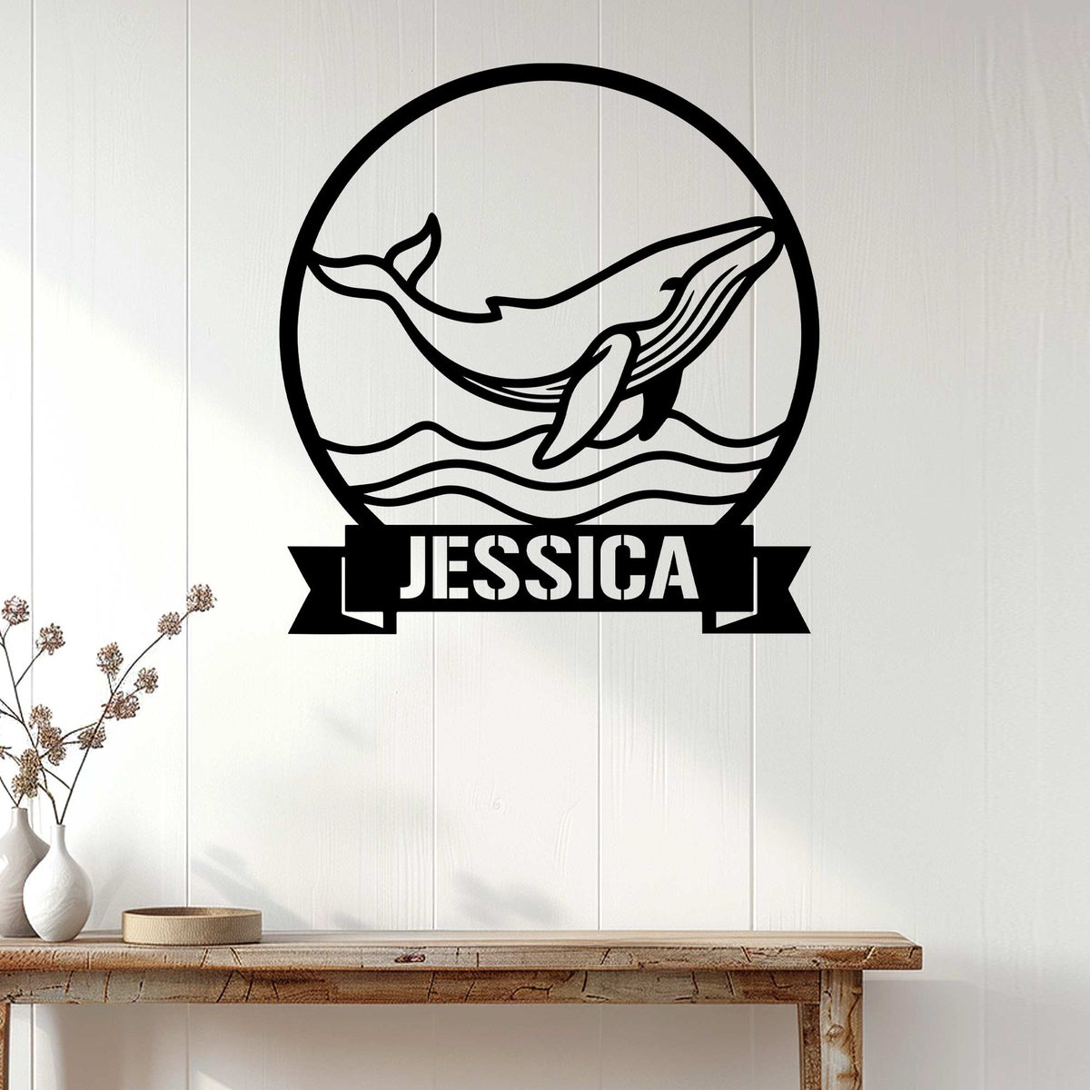 Whale metal wall decor displayed on white paneling above a wood console table