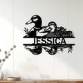 Black duck wall sign displayed on a light wood-paneled wall in a home decor setting