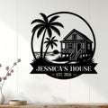 Black beach house wall sign displayed on white paneling as coastal home decor