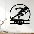 Black sprinter silhouette metal sign displayed as athletic wall decor on a light wood-paneled wall