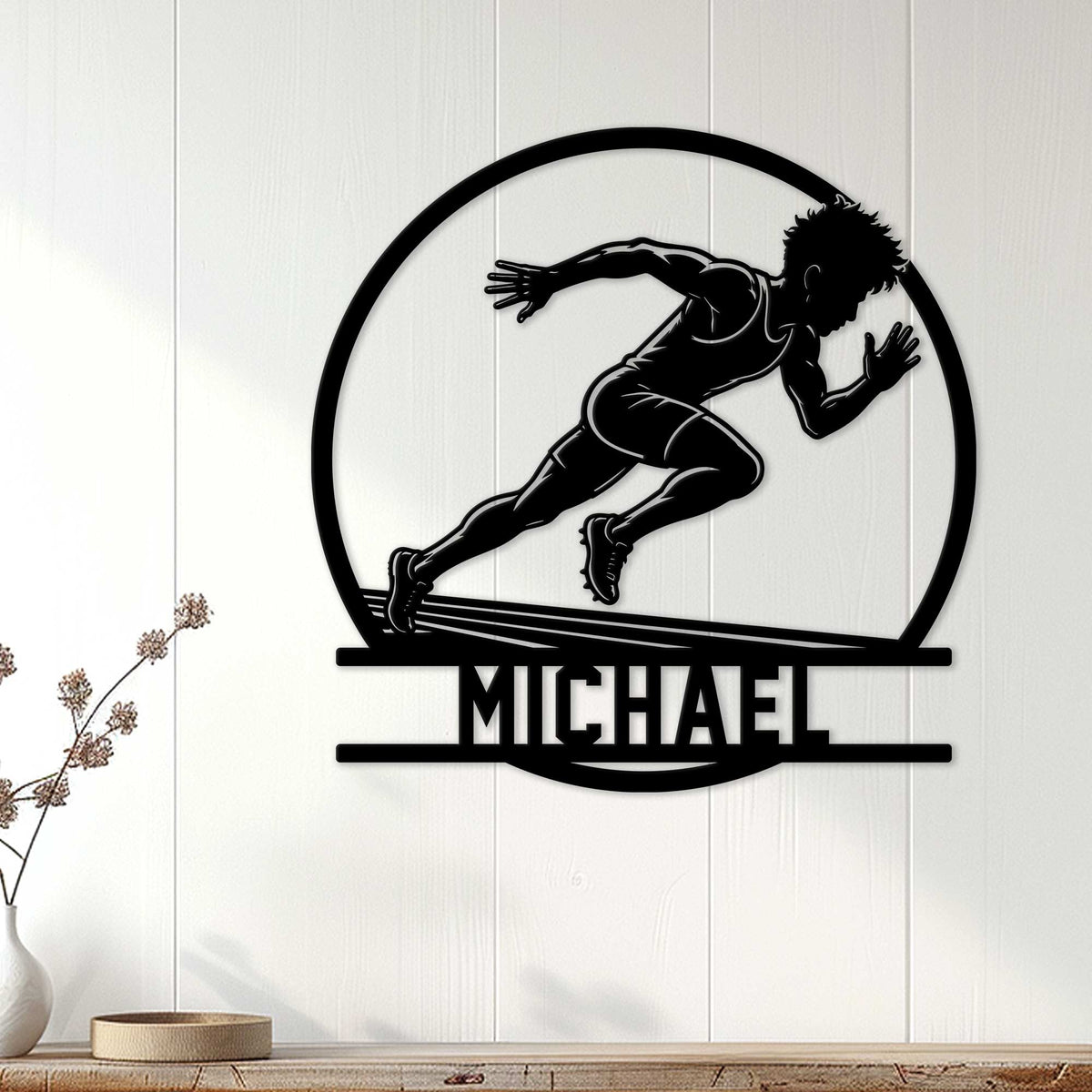 Black sprinter silhouette metal sign displayed as athletic wall decor on a light wood-paneled wall