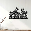 Black cardinal pair wall sign displayed on a light paneled wall above a console table