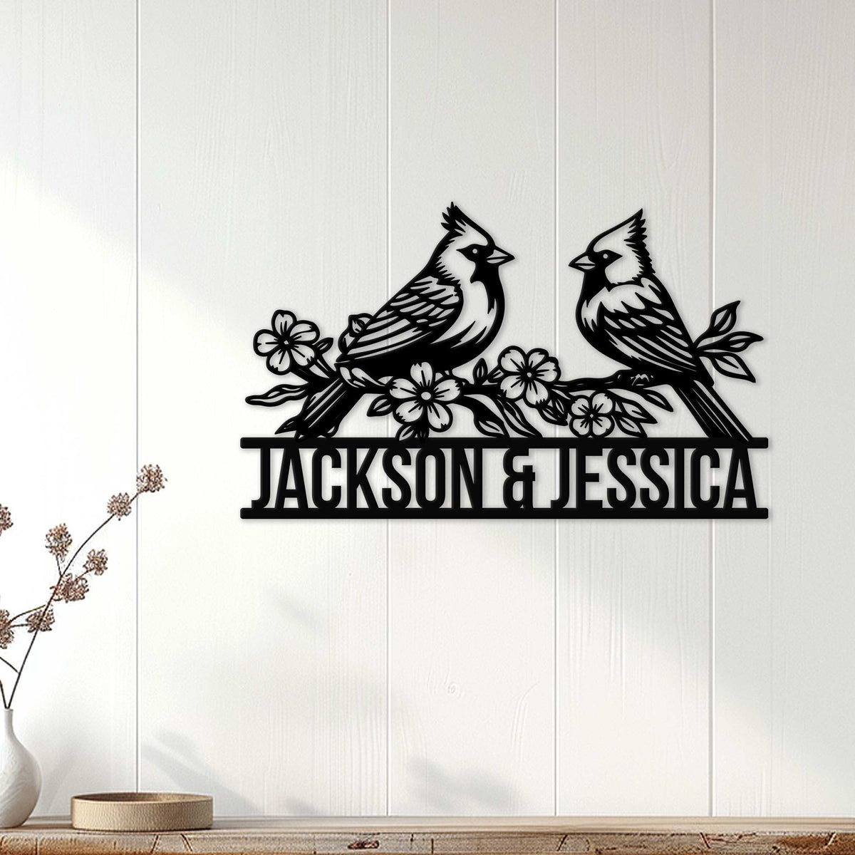Black cardinal pair wall sign displayed on a light paneled wall above a console table