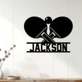 Black table tennis wall sign displayed on a light wood-paneled wall in a modern room