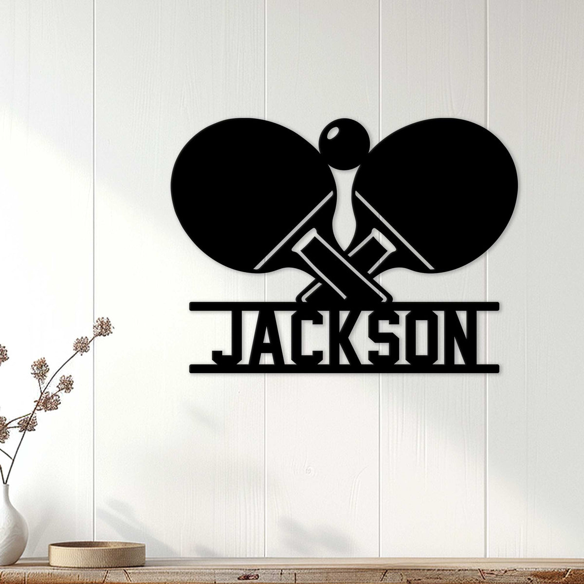 Black table tennis wall sign displayed on a light wood-paneled wall in a modern room