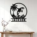 Lifestyle display of an orca metal wall sign above a console table in a bright coastal home