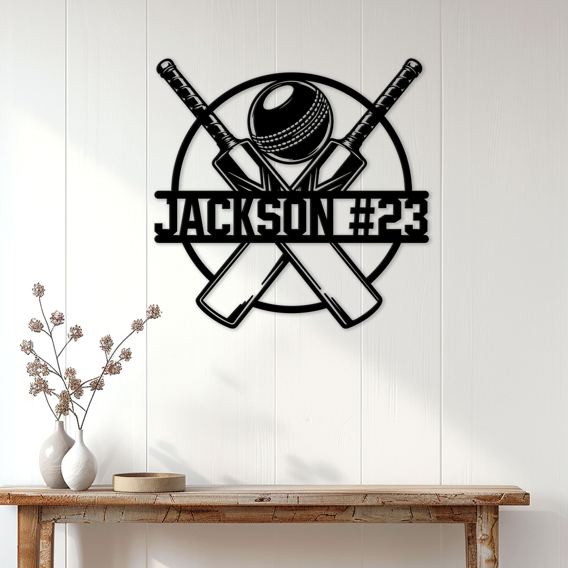 Cricket wall decor displayed above a console table, featuring crossed bats and a detailed cricket ball