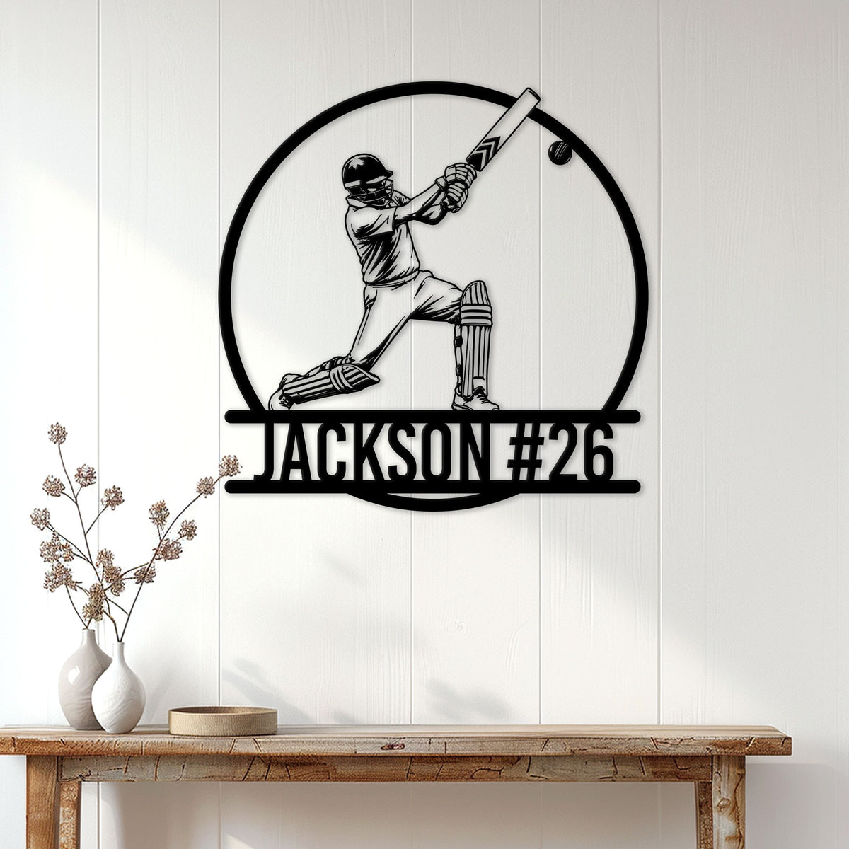 Cricket batsman metal wall sign displayed on a bright paneled wall above a console table